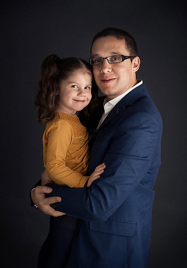 father and young daughter hugging smiling to camera