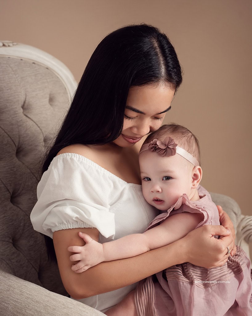 one year old baby cuddling into mothers lap