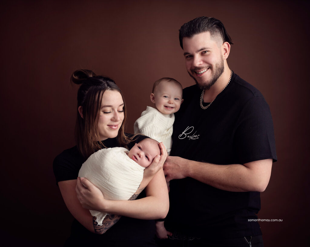family portrait of mother, father, baby and toddler