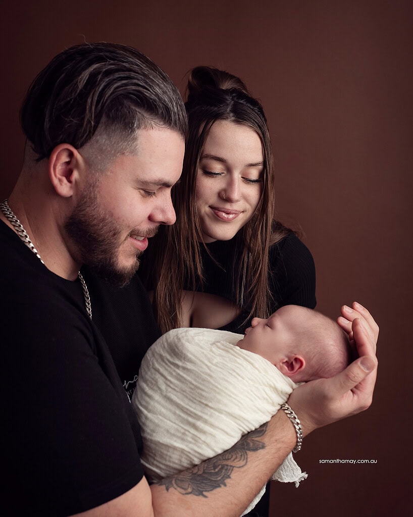 mother and father holding baby
