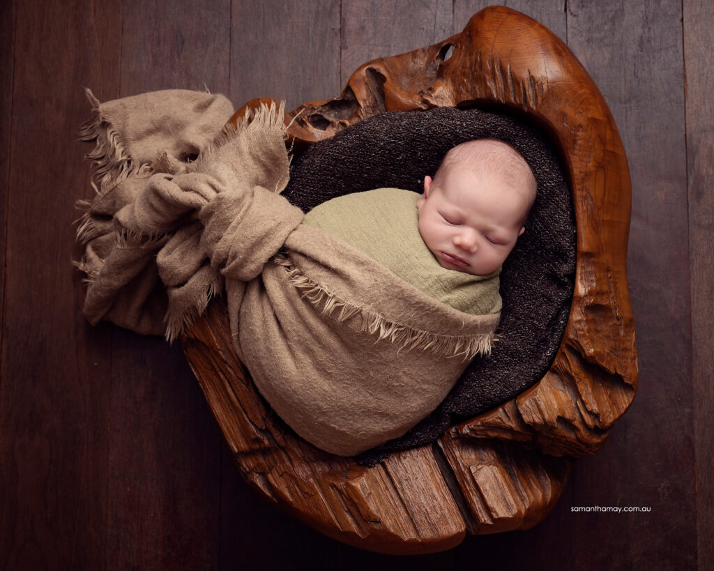 carved wooden bowl with sleeping baby