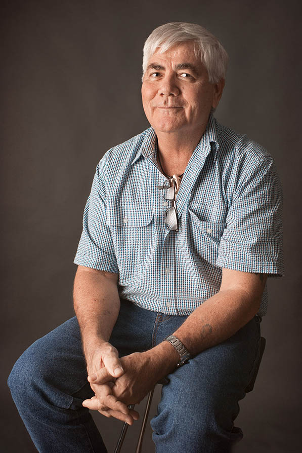 seated male headshot glasses hanging from collar